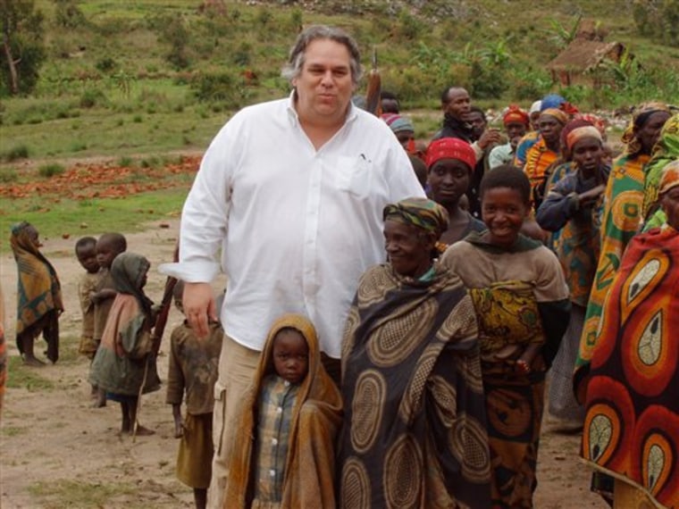 In this December 2007 photo obtained by The Associated Press, the Rev. Carl Keyes stands with impoverished people of the Batwa Tribe in Burundi during a delivery of relief supplies to the area. 